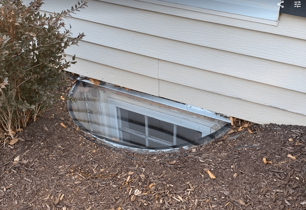 40x16 sloped basement window well cover surrounded by mulch